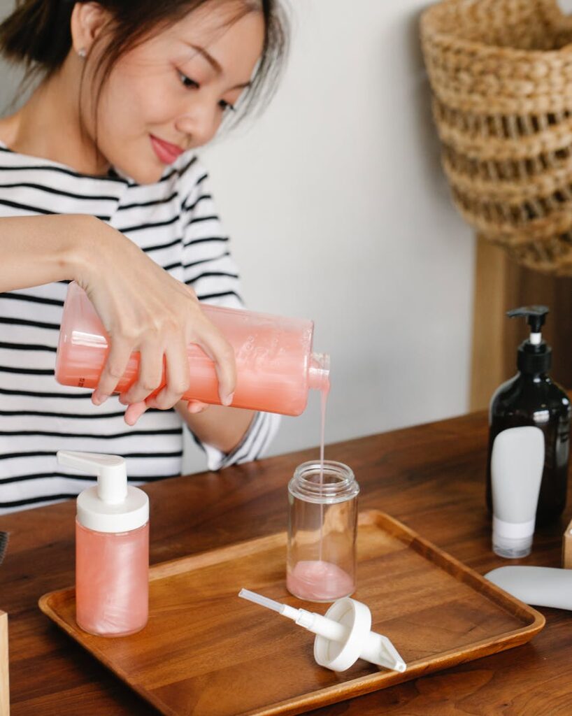 anonymous asian woman pouring soap from dispenser